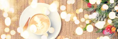 Kahve ya da chai latte sanat ile çay. ve Noel dekor. Tatil bachground. Zaman kavramı, Noel ve memnuniyetti. Pastel renkler, sıcak tonlama. Yatay başlık biçimi. Festival kalın bokeh