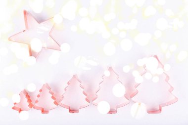 Flatlay yıldız ve tatil ağaç bakır çerez kesici beyaz köpüklü arka planda satır. Tatil, Noel ve yeni yıl kavramı. Rahat ev gibi ayrıntılar. Düz yatıyordu, en iyi görünümü arka plan. Yatay, parlak ışık bokeh arka plan