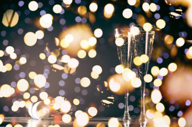 İki bardak şampanya ile Noel oyuncaklar. Festival ışıklar bokeh Noel arka plan. Yeni yıl tatilleri kutlama. Yatay, sıcak sesi, kalın ışık bokeh