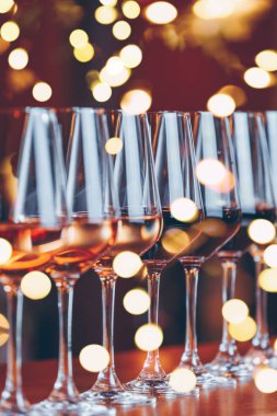 Üst üste gözlük şarap. Şarap tadımı tablo kutlama açık büfe. Gece hayatı, kutlama ve eğlence kavramı. Dikey, soğuk tonlu görüntü, parlak ışıklar bokeh arka plan