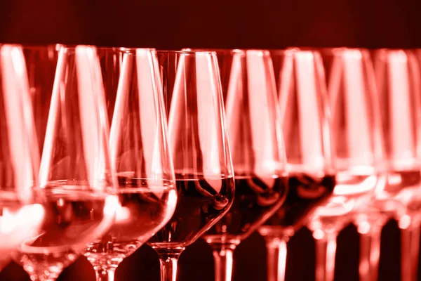 Wine glasses in a row. Buffet table celebration of wine tasting. Nightlife, celebration and entertainment concept. Horizontal. Coral accent - color of the year 2019