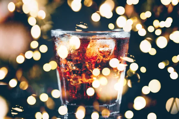 Cuba libre cocktail at the bar stand. Dark background. Horizontal. Bold festive bokeh