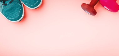 Spor ayakkabı ve halter sağlam zemin üzerinde. Sportif ve sağlıklı spor kavram formunuzu koruyun. Başlık biçimi, mercan ton yaşayan Üstten Görünüm