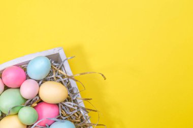 Beyaz bir tepsi çok renkli yumurtalar. Yaratıcı Paskalya kavramı. Modern düz sarı arka plan.