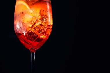 Lezzetli alkollü aperol spritz trendy kokteyl ile siyah arka plan üzerine Portakal dilim. Makro.