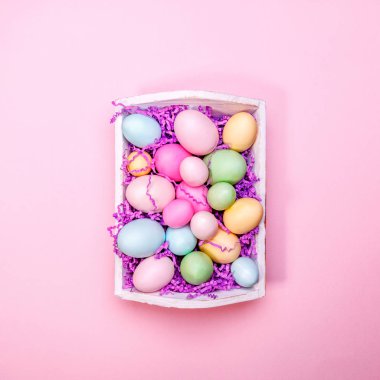 Beyaz bir tepsisinde çok renkli yumurta. Yaratıcı Paskalya konsepti. Modern sağlam pembe arka plan.