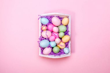Beyaz bir tepsisinde çok renkli yumurta. Yaratıcı Paskalya konsepti. Modern sağlam pembe arka plan.