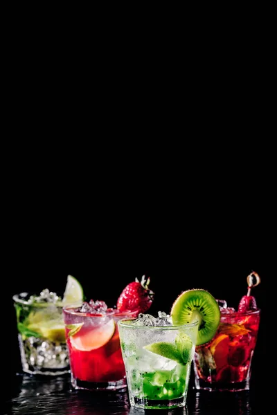 Fire farverige velsmagende alkoholiske cocktails i træk i baren står . - Stock-foto