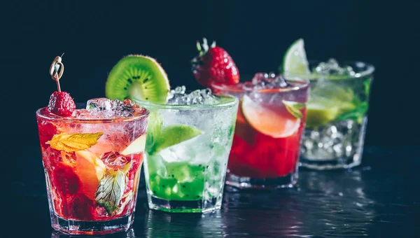 Fyra färgglada läckra alkoholhaltiga cocktails i rad i baren står. — Stockfoto
