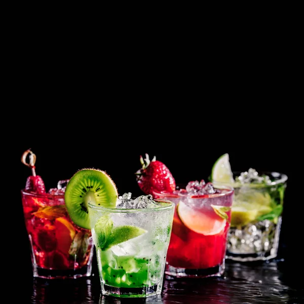 Four colorful tasty alcoholic cocktails in a row at the bar stand. — Stock Photo, Image