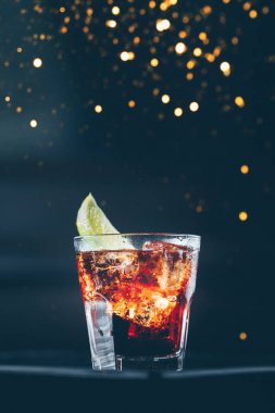 Bar standında Küba libre kokteyli. Karanlık arka plan. Şenlikli tatil bokeh