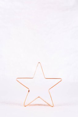 Beyaz ışıl ışıl arka planda parlak ışıklı Star Copper kurabiye makası. Noel tatili ve yeni yıl geçmişi