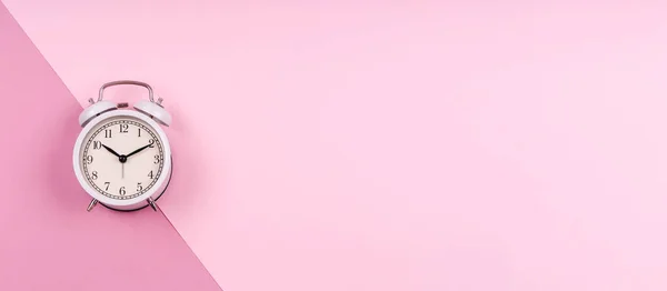 Симпатичные белые ретро-часы на пастельно-розовой капле дуотона — стоковое фото