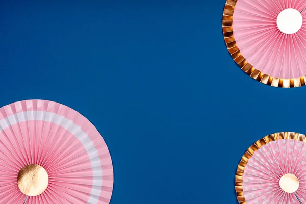 Pink and golden paper fans on classic blue drop — Stock Photo, Image