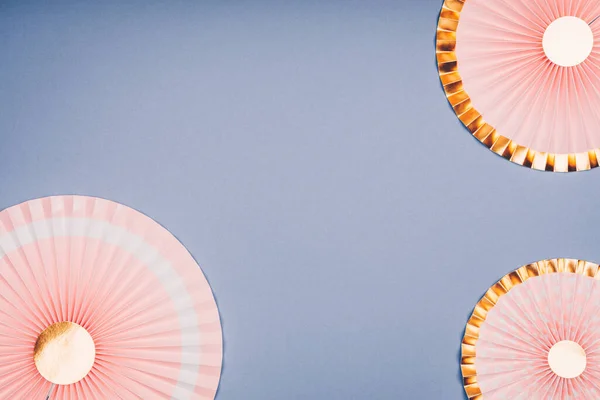 Różowe i złote papierowe wentylatory na jasnoniebieskiej kropli — Zdjęcie stockowe