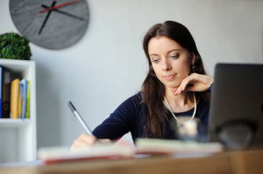 Ofiste dizüstü bilgisayar kullanan ciddi bir iş kadınının portresi