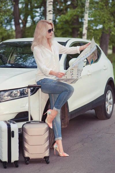 A blonde woman near with luggage