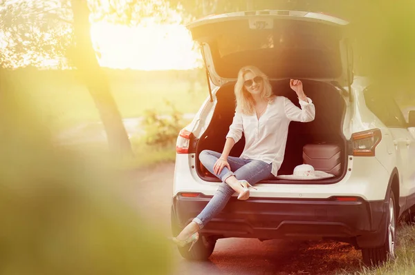 A blonde woman near with luggage