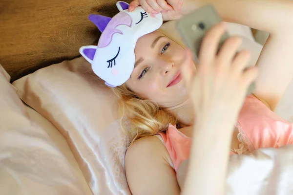 Sorrindo Menina Segurando Smartphone Suas Mãos Cama Fotografias De Stock Royalty-Free