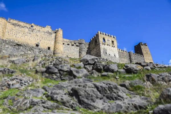 tilt shift landscape castle in  mountains stones mountains grass blue sk