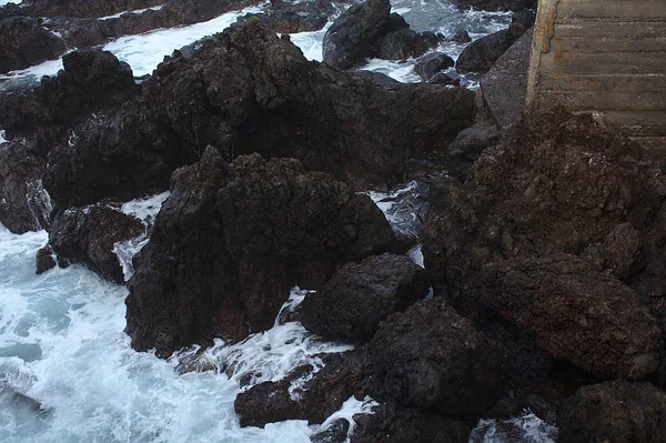 Storm på stranden med svart, grått, mörkt vulkaniska klippor och sto — Stockfoto