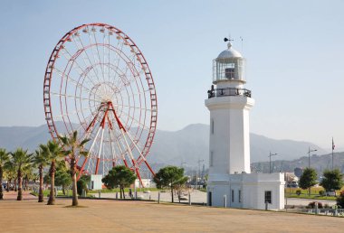 Batumi 'deki Seafront gezinti güvertesinde dönme dolap ve deniz feneri. Adjara Özerk Cumhuriyeti. Georgia