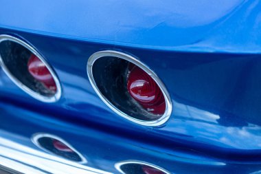 Eski mavi bir arabanın parçası. Arka tarafta kırmızı ışıklar.