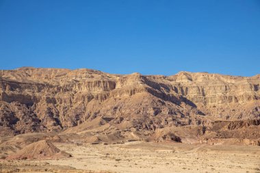 İsrail 'in Arava çölündeki Timna Park manzarası. Sarı ve kırmızı dağlar, kayalık yüzey ve mavi gökyüzü