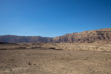 İsrail 'in Arava çölündeki Timna Park manzarası. Sarı ve kırmızı dağlar, kayalık yüzey ve mavi gökyüzü