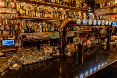 Bir sürü alkollü içki, bira muslukları ve CD 'leri olan renkli bir bar.