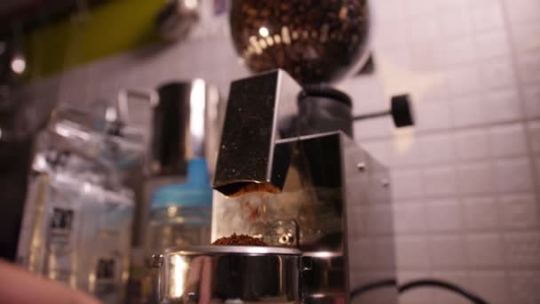 Elektrische koffiemolen maalt verse geroosterde bonen in filterhouder. Slow motion — Stockvideo