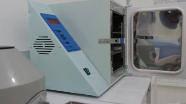 Beyaz eldiven elinde tıp aletleri kutu sterilizasyon kuru sıcak koymak.
