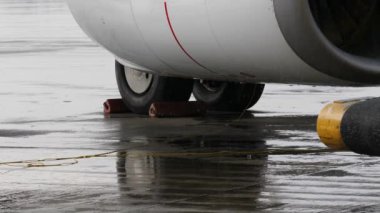 Uçak iniş takımı ve jet motoruna ağır yağmur altında chocked jantlar