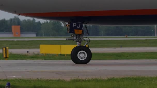 Dispositivi di atterraggio degli aeromobili in rullaggio. Ruota del foro e parte della fusoliera di un aeroplano — Video Stock