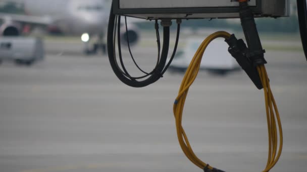 Nahaufnahme von gelben und schwarzen großen Kabeln, die unter der Düsenbrücke im Flughafen hängen — Stockvideo