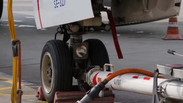 Vliegtuigen grondafhandeling. Fore onderstel met pushback sleepboot trekhaak en power cord — Stockvideo