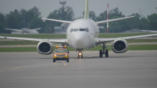 Moskva, Ryssland - 25 juli 2018: Boeing 737 flyttar bakom Följ mig bilen på taxibana på Sheremetyevo flygplats — Stockvideo