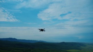Dron yeşil dağların üzerinde bulutlu gökyüzüne uçar
