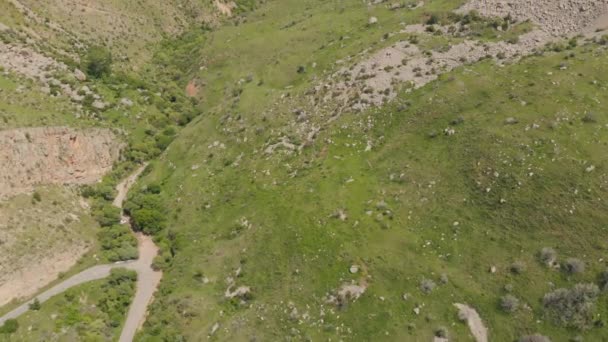 Fliegen über Berghang mit grünem Gras und Steinen bedeckt — Stockvideo