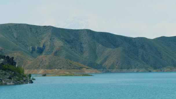 Птицы летают над водной поверхностью водохранилища на реке в армянских горах — стоковое видео