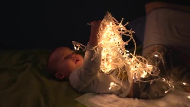 Brincar menino feliz com guirlanda LED emaranhada brilhando em diferentes modos — Vídeo de Stock