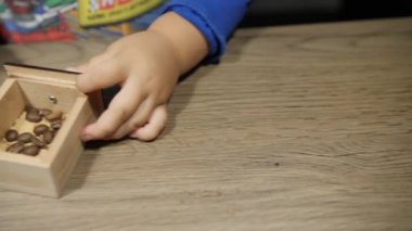 Bebek el ile kahve değirmeni küçük ahşap kutu fasulye ile ayarlar. Elinde yakın çekim