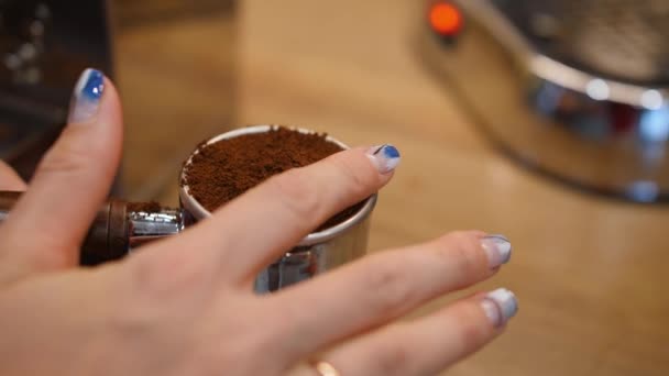 Frau nivelliert gemahlenen Kaffee mit dem Finger in Filterhalter für Kaffeemaschine. Nahaufnahme — Stockvideo