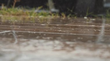 Yağmur damlaları ahşap yere düşer. Ağır yağmur su sıçramalarına görüntüsünü kapatmak