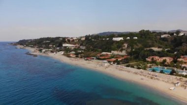 Sandy beach oteller ve tatil köyleri ile. Masmavi denizi ve İtalya'nın engebeli kıyı şeridi havadan görünümü