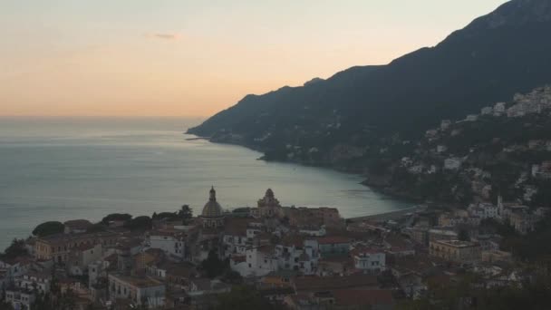 Solnedgång över italienska kuststad. Panoramautsikt över byggnader på kullarna längs havsstranden — Stockvideo