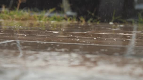 As gotas de chuva caem no chão de madeira. Feche o tiro de salpicos da chuva pesada — Vídeo de Stock