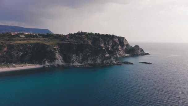 Donkere regen wolk over ruige rotsachtige kaap en turquoise zee wateren. Luchtfoto van Capo Vaticano klif, Italië — Stockvideo