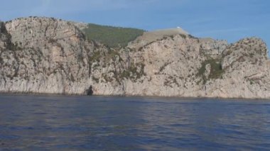 Hızlı sarp kayalık uçurum üzerinde mavi deniz güneşli günde tekne. Punta Campanella, İtalya