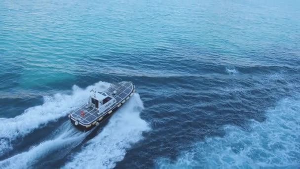 O barco piloto flutua rápido da balsa em direção à cidade à beira-mar. Mar azul profundo — Vídeo de Stock